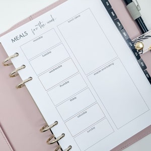 Peut inclure: Une page de planificateur blanche avec un planificateur de repas hebdomadaire. La page est divisée en sept sections pour chaque jour de la semaine, avec de l'espace pour écrire les repas. Il y a aussi des sections pour les idées de déjeuners et les collations et la pâtisserie.