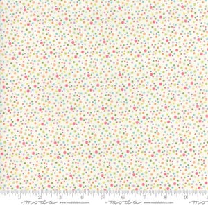 May include: Off-white fabric covered in a pattern of small, colorful polka dots. The dots are in shades of pink, green, blue, yellow, and purple. A ruler is at the bottom of the image, with the word "moda" and website address printed on it.