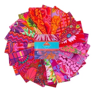 May include: A collection of colorful fabric squares arranged in a circular pattern. The fabrics feature vibrant floral and geometric designs in shades of red, pink, orange, and purple. A central package is wrapped with a turquoise band.