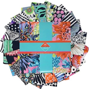 May include: A collection of colorful fabric squares with various floral and abstract patterns. The fabrics are arranged in a circular shape and tied with a turquoise ribbon. The fabric squares feature designs in shades of pink, orange, blue, black, and white.