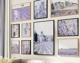 Puede incluir: Una sala de estar con un sofá beige claro y un puf gris. La pared detrás del sofá está decorada con una pared de galería de impresiones enmarcadas que representan campos de lavanda, una iglesia y una mariposa.