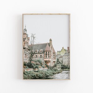 May include: A framed print of a historic building with a red-tiled roof and a tower. The building is made of stone and is set beside a river. The sky is overcast.