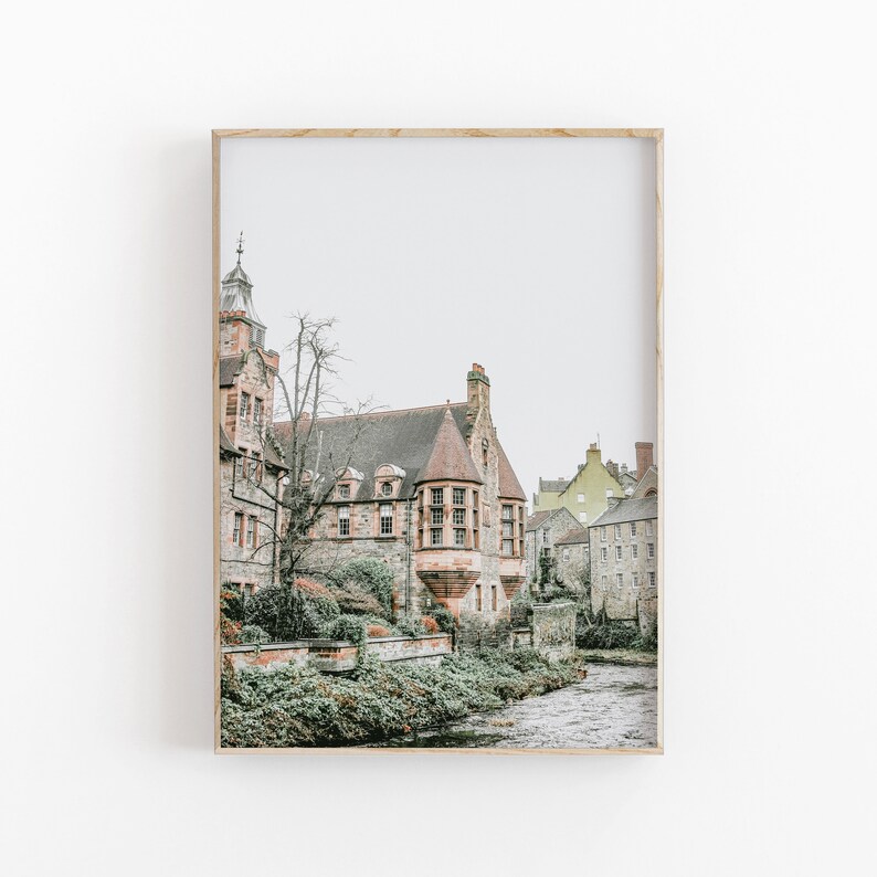 May include: A framed print of a historic building with a red-tiled roof and a tower. The building is made of stone and is set beside a river. The sky is overcast.