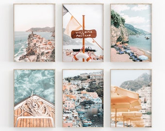 May include: Six framed prints of colorful scenes from Positano, Italy. The prints feature a view of the town from the water, a close-up of a boat, a beach with umbrellas, and a sign that says "Welcome to Positano".