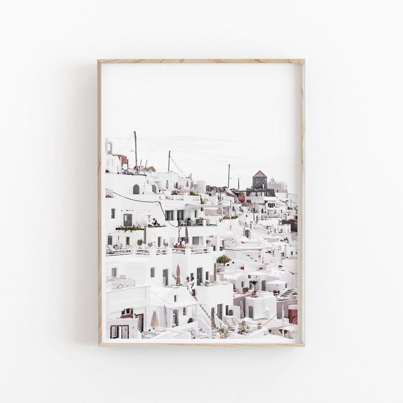 May include: A photograph of a white, hillside village with a cluster of buildings, some with blue doors and windows. The buildings are stacked on top of each other, creating a unique and picturesque scene.