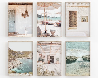 May include: Set of six framed prints featuring various scenes of a Mediterranean coastal town. The prints include a white building with a wooden door, a beach with lounge chairs and umbrellas, a view of a rocky coastline with turquoise water, and a patio with a wooden pergola.