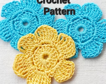 May include: Two crocheted flowers, one yellow and one blue, on a white fabric background. The image includes the text "Crochet Pattern".