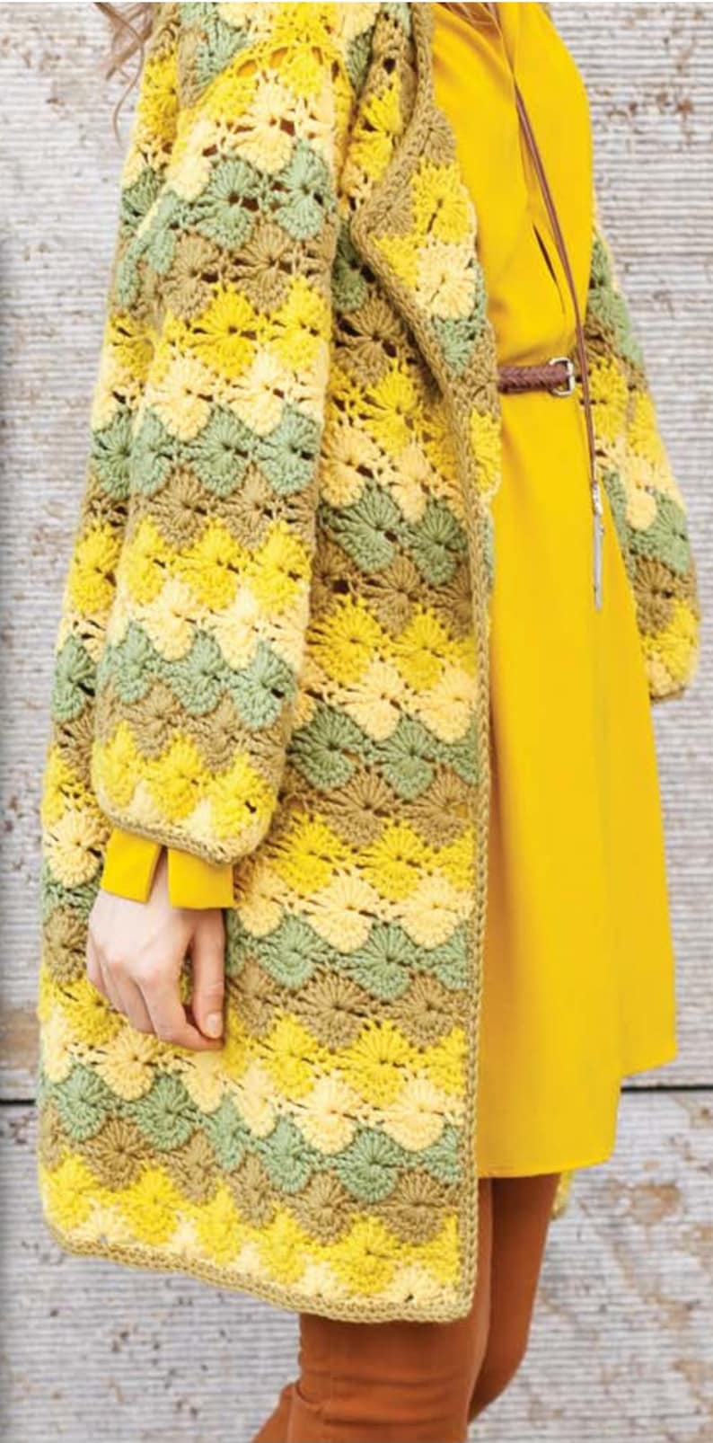 K&ouml;nnte beinhalten: Eine geh&auml;kelte Strickjacke in Gelb, Gr&uuml;n und Braun. Die Strickjacke hat einen langen, offenen Vorderteil und eine lockere Passform. Sie ist mit einem Stichmuster gearbeitet, das einen wellenf&ouml;rmigen Effekt erzeugt.