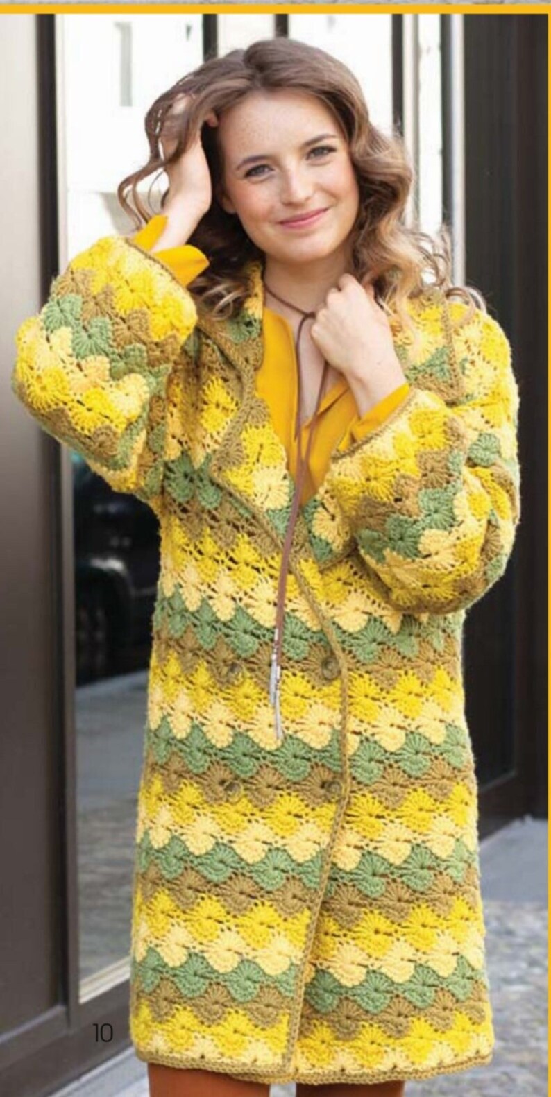 K&ouml;nnte beinhalten: Eine gelbe, gr&uuml;ne und braune geh&auml;kelte Strickjacke mit einem langen, offenen Vorderteil und einem diagonalen Knopfverschluss. Die Strickjacke hat ein strukturiertes, wellenf&ouml;rmiges Muster.