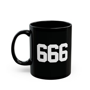 May include: Black ceramic coffee mug with a white 666 graphic.