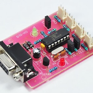 May include: A pink circuit board with a black serial port connector, a small chip labelled "PIC16F616", and a green LED. The board has several rows of pins labelled "CH" and "J1" and "J2".