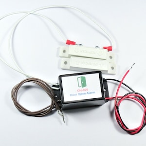 May include: A white door open alarm system with a black control box labeled "CH-026 Door Open Alarm". The system includes two white magnetic sensors with red wires and a brown wire.