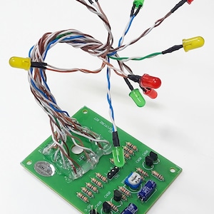 May include: A green circuit board with electronic components and coloured LEDs. Red, yellow, and green LEDs are connected by wires to the board. The text "FUTURE KIT" is visible. Various resistors and capacitors are also present.