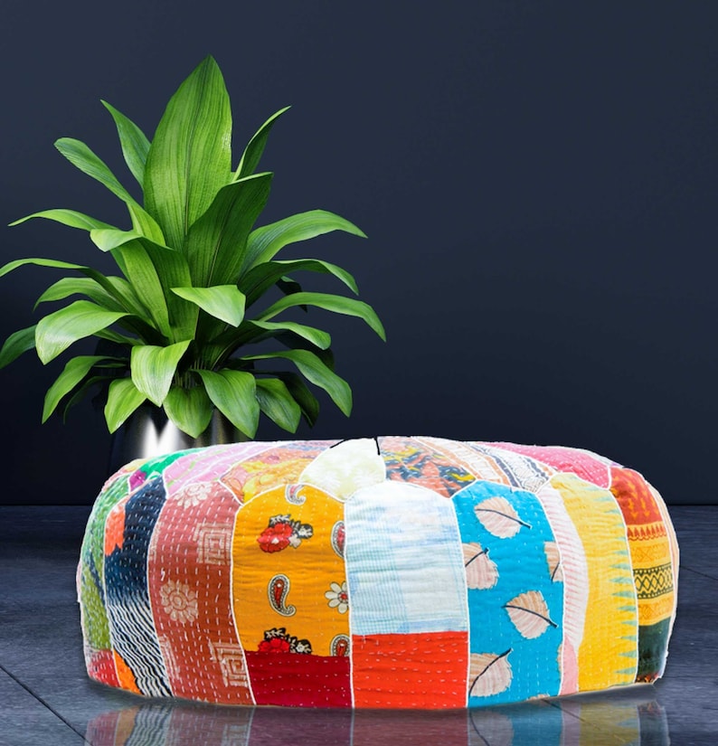 May include: A round, colorful patchwork pouf ottoman with a variety of fabrics and patterns, including floral, paisley, and geometric designs. The pouf is filled with a soft, comfortable material and is perfect for adding a touch of bohemian style to any room.