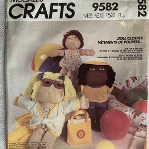 Op de afbeelding: Een naaipatroon voor poppenkleding, met een Cabbage Patch Kid pop die een witte badjas en een zonnebril draagt. Het patroon is voor poppen van 30,5 cm, 40,5 cm en 46 cm. Het patroon is getiteld "Doll Clothes" en "Vêtements de Poupées..." in het Frans. Het patroonnummer is 9582.