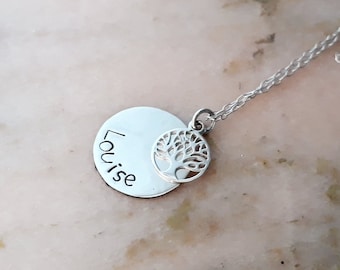 May include: Silver necklace with a round pendant engraved with the name "Louise" and a small tree charm.