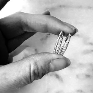 May include: Two silver beaded rings stacked on top of each other. The rings are simple and delicate.