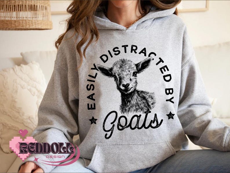 May include: A gray hoodie with a black graphic that says "Easily Distracted By Goats" and features a black and white illustration of a goat's head.