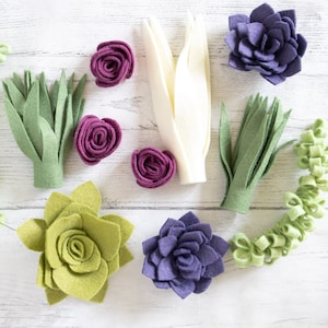 May include: A collection of felt flower embellishments in various colors and styles, including succulents, roses, and leaves. These felt flowers are perfect for adding a touch of handmade charm to crafts, cards, and other projects.
