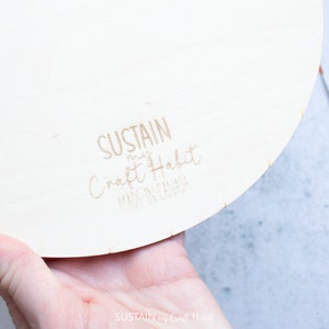 Peut inclure: Gros plan sur un disque rond en bois avec le texte "SUSTAIN my Craft Habit MADE IN CANADA" imprim&eacute; au dos.