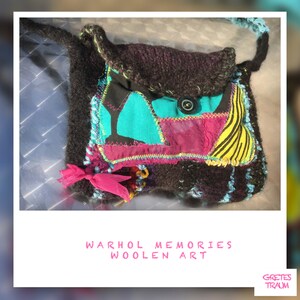 Könnte beinhalten: Eine kleine, braune Stricktasche mit einer Patchwork-Klappe aus türkisfarbenem, rosa und gelbem Stoff. Die Tasche hat einen einzigen Knopfverschluss und ein rosafarbenes Schleifenband. Der Text "WARHOL MEMORIES WOOLEN ART" ist unter der Tasche gedruckt.
