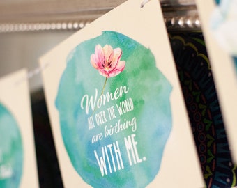 May include: A banner with a watercolor design featuring a pink flower and teal and green background. The banner reads "Women all over the world are birthing with me."