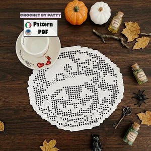 May include: A white circular crochet doily featuring a jack-o'-lantern pattern. The image includes text that reads CROCHET BY PATTY, Pattern, and PDF, alongside a white teacup, small pumpkins, glass bottles, a metal key, and a black spider.