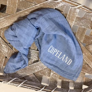May include: A light blue fabric square with the word "COPELAND" embroidered in white.