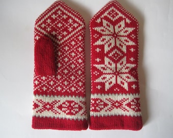 May include: Pair of red and white knitted mittens with a snowflake pattern. The mittens have a thumb hole and a separate finger section.
