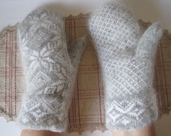 May include: A pair of gray and white knitted mittens with a fuzzy texture. The mittens have a geometric pattern.