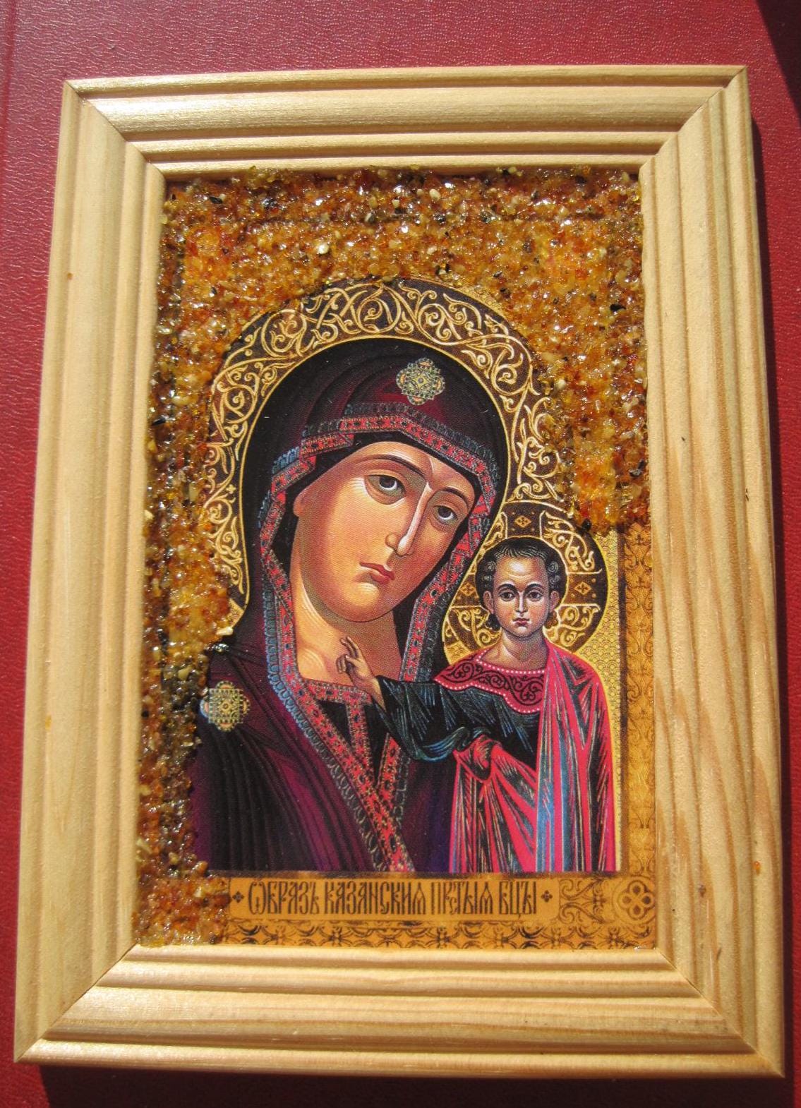 New Orthodox miraculous icon of the Mother of God of Kazan with amber chips on a wooden frame