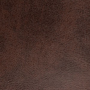 Puede incluir: Primer plano de una superficie de cuero marr&oacute;n oscuro texturizado. El cuero tiene un grano natural y un color rico y c&aacute;lido, ideal para tapicer&iacute;a o artesan&iacute;a.