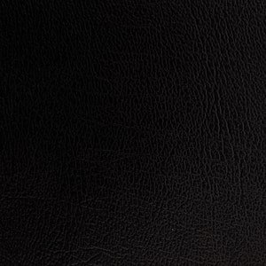Puede incluir: Primer plano de una textura de cuero negro. La superficie tiene un grano fino y granulado, con sutiles variaciones de tono y sombra. La apariencia general es oscura y rica, lo que sugiere un material duradero.