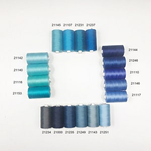 May include: A collection of 16 spools of thread in various shades of blue, arranged in a square pattern. The spools are labeled with numbers, including 21142, 21140, 21116, 21153, 21145, 21107, 21231, 21237, 21234, 21000, 21235, 21249, 21143, 21251, 21144, 21246, 21110, 21146, and 21117.