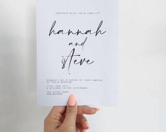 Op de afbeelding: Een witte huwelijksuitnodigingskaart met zwarte tekst. De kaart kondigt het huwelijk van Hannah en Steve aan op 11 juni 2021 om 14:00 uur in The Essex Barn in Chelmsford.