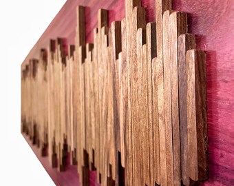 May include: A wooden wall art piece with a sound wave design. The wood is a dark brown color and is set against a deep purple background.