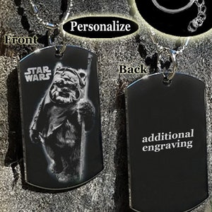 May include: A black metal dog tag necklace or keychain with a laser engraved image of a Star Wars character,  "STAR WARS" text, and the option for additional engraving on the back.