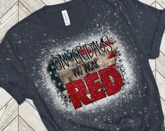 May include: A dark heather navy blue t-shirt with a distressed American flag design and the text "On Fridays We Wear Red".