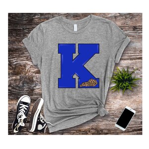 May include: A grey t-shirt with a blue letter K and a leopard print outline of the state of Kentucky.