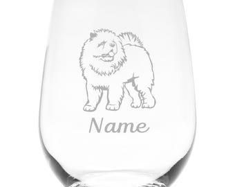 May include: A clear stemless wine glass featuring an etched illustration of a fluffy Chow Chow dog standing in profile. Below the dog, the word Name is etched in a cursive script font. The glass has a rounded, tapered shape with a smooth rim.