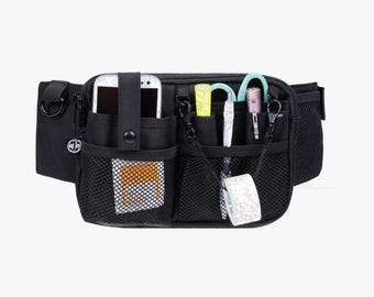 May include: Black fanny pack with multiple pockets and compartments. Features a phone holder, mesh pockets, and various tools like scissors and pens. Ideal for organizing essentials.
