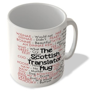 May include: White ceramic mug with a black and red design. The mug features the words "The Scottish Translator Mug" with a list of Scottish words and their English translations.