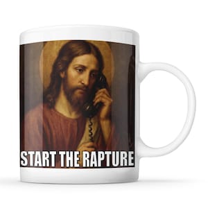 May include: White ceramic mug with an image of Jesus on the phone. The mug has the text "START THE RAPTURE" in white. The handle is white.