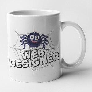 May include: White ceramic mug featuring a black spider on a web design. The text "WEB DESIGNER" is printed on the mug.