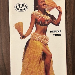 May include: A vintage travel brochure for an Aloha Week Tour to Hawaii in October 1959. The brochure features a woman in a hula skirt and lei, holding a fan. The text reads "Aloha Week Tour To Hawaii, October 1959, Deluxe Tour, via Northwest Orient Airlines".