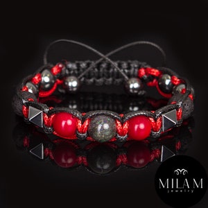 May include: A black braided bracelet with red and gray beads, black lava rock beads, and silver pyramid-shaped accents.