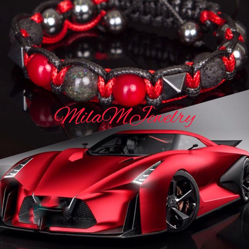 May include: A red and black bracelet with black lava rock beads, red gemstone beads, and silver metal accents. The bracelet is tied with a red cord.
