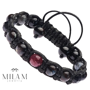 May include: Black braided bracelet with black and blue gemstone beads and a single red gemstone bead. The bracelet has a sliding knot closure.