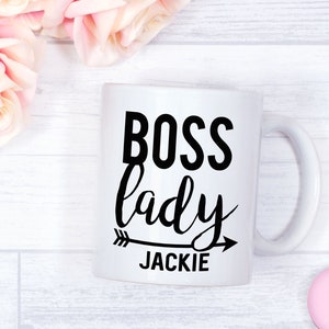 May include: White ceramic mug with black text that reads "Boss lady" with an arrow pointing to the right and the name "JACKIE" underneath.