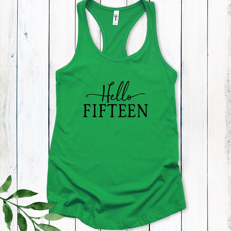 May include: Green tank top with the text "Hello Fifteen" in black lettering.